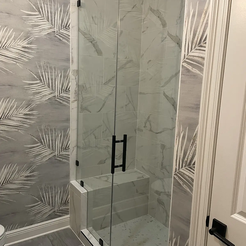 Shower enclosure with tiles and bench and glass doors by Dunn's Flooring Depot