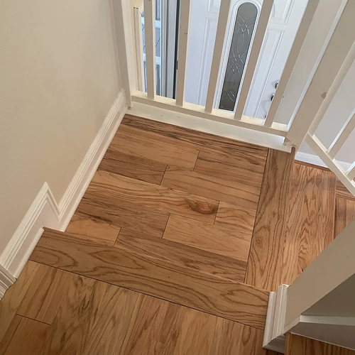 Wood floor landing on stairway by Dunn's Flooring Depot